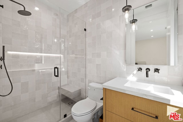 bathroom featuring tile walls, decorative backsplash, vanity, an enclosed shower, and toilet