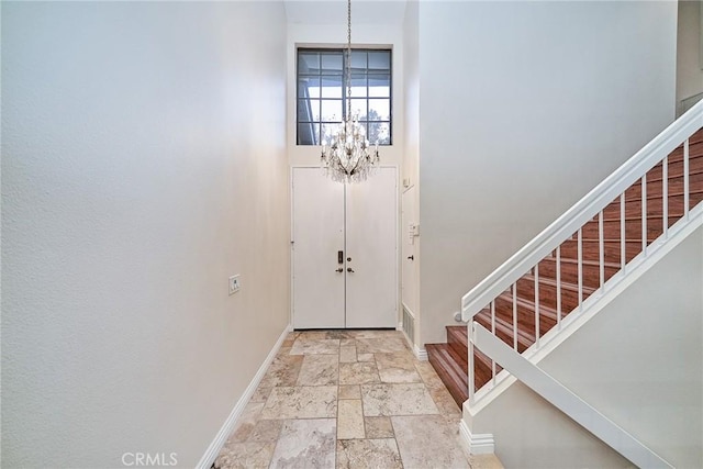 foyer with a towering ceiling and a notable chandelier