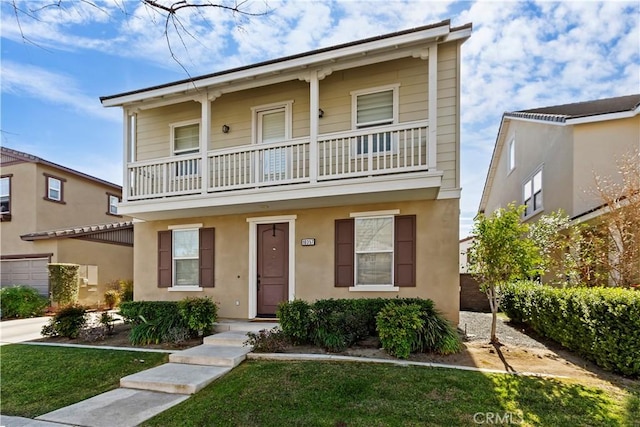 front facade featuring a front yard and a balcony