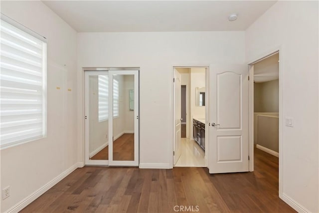 unfurnished bedroom with dark wood-type flooring