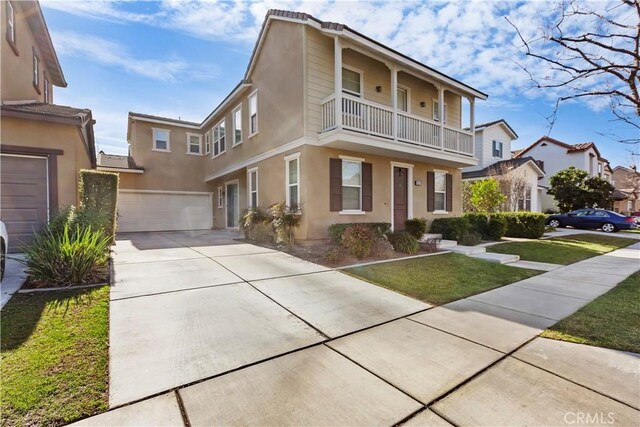 view of property with a garage, a front yard, and a balcony