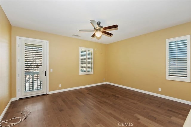 unfurnished room featuring dark wood-type flooring and ceiling fan