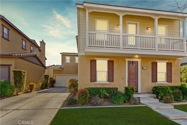 view of front facade with a garage, a front yard, and a balcony