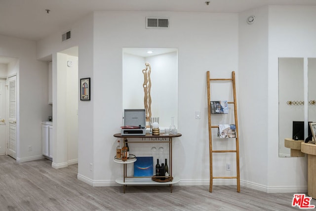 hallway with light hardwood / wood-style floors