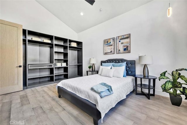 bedroom featuring hardwood / wood-style floors and high vaulted ceiling