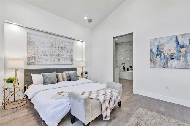 bedroom featuring ensuite bathroom, high vaulted ceiling, and wood-type flooring