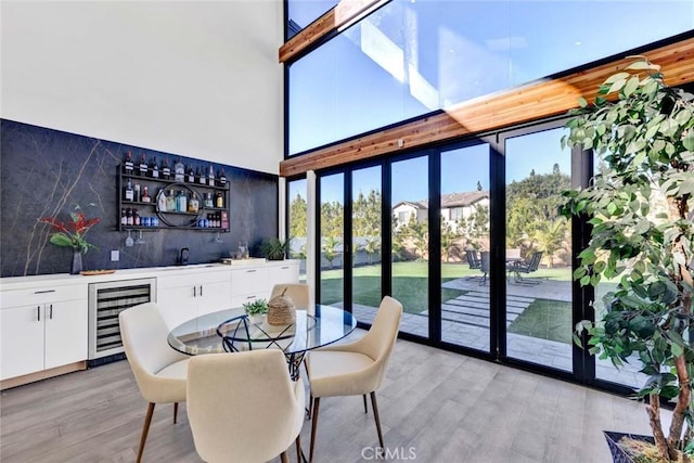 sunroom / solarium featuring indoor wet bar and beverage cooler