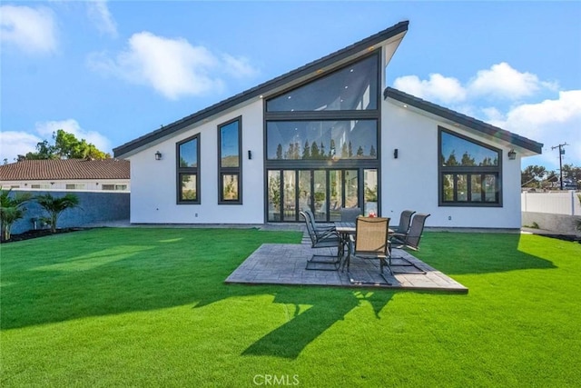 rear view of property featuring a patio area and a lawn