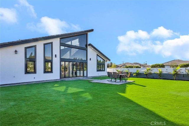 rear view of house featuring a patio and a lawn