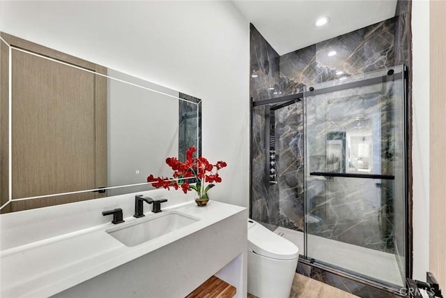 bathroom featuring hardwood / wood-style flooring, vanity, toilet, and a shower with door