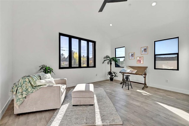 living room featuring hardwood / wood-style floors, high vaulted ceiling, and ceiling fan