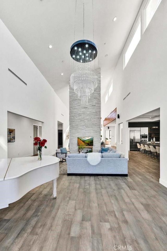 interior space with an inviting chandelier, a towering ceiling, and hardwood / wood-style flooring