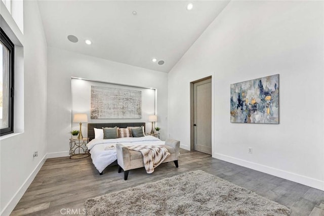 bedroom with hardwood / wood-style floors and high vaulted ceiling