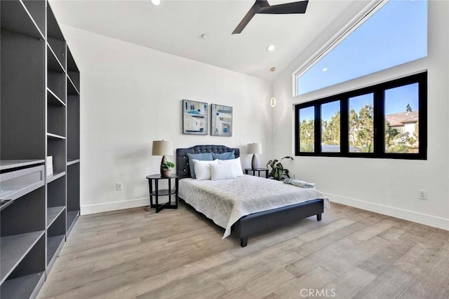 bedroom featuring high vaulted ceiling, light hardwood / wood-style floors, and ceiling fan