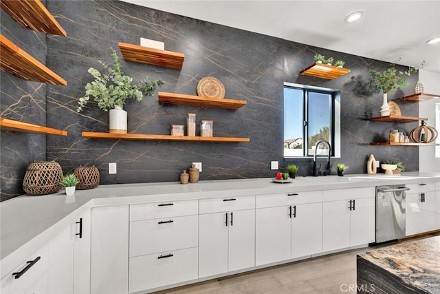 bar with white cabinetry, sink, and dishwasher