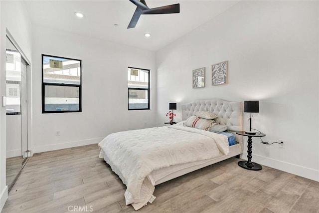 bedroom with multiple windows, light wood-type flooring, and ceiling fan