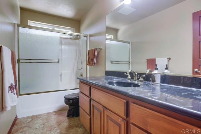 full bathroom featuring enclosed tub / shower combo, vanity, toilet, and tile patterned floors