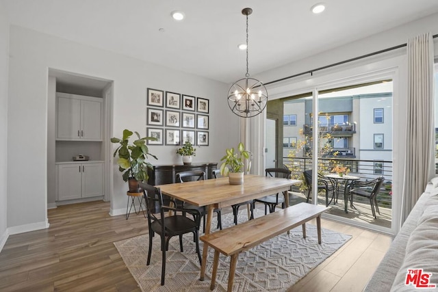 dining area featuring hardwood / wood-style flooring and a chandelier