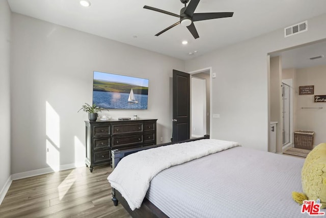 bedroom featuring hardwood / wood-style flooring, ceiling fan, and ensuite bathroom