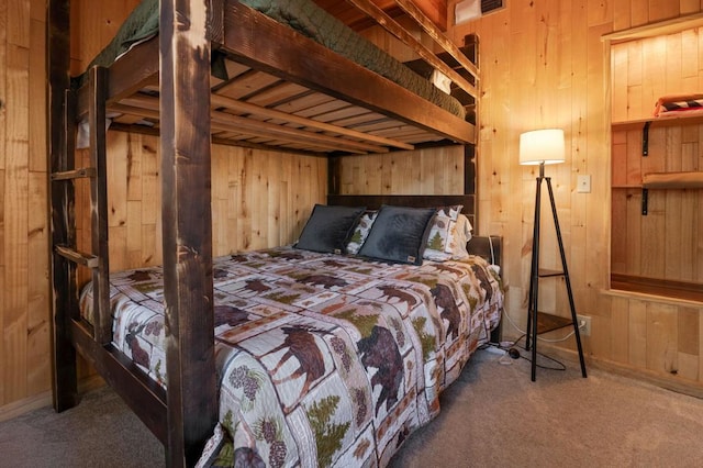 bedroom featuring wooden walls and carpet flooring