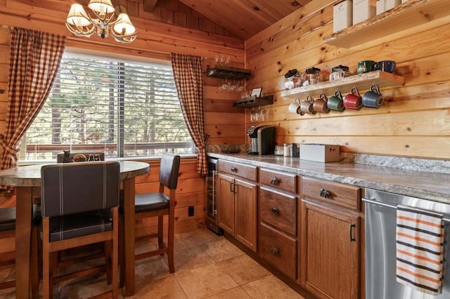 kitchen featuring vaulted ceiling, light tile patterned floors, wooden walls, pendant lighting, and beverage cooler