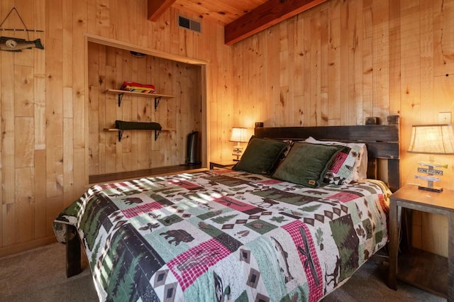 bedroom with beam ceiling, wooden walls, wooden ceiling, and carpet flooring