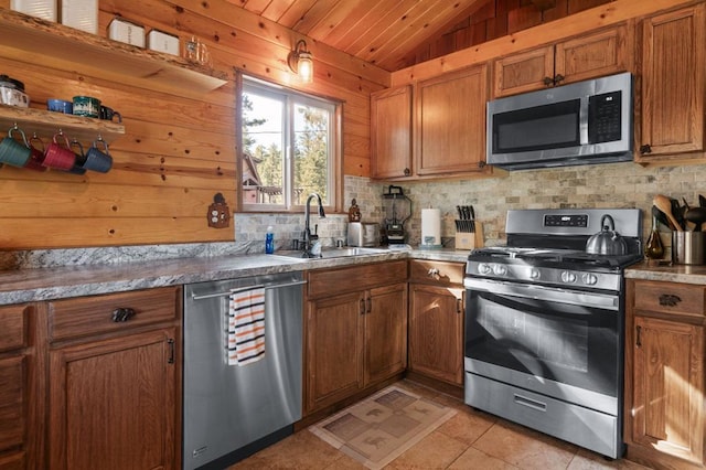 kitchen featuring light tile patterned flooring, lofted ceiling, sink, stainless steel appliances, and decorative backsplash