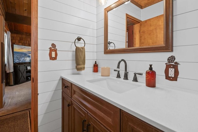 bathroom featuring vanity and wooden walls