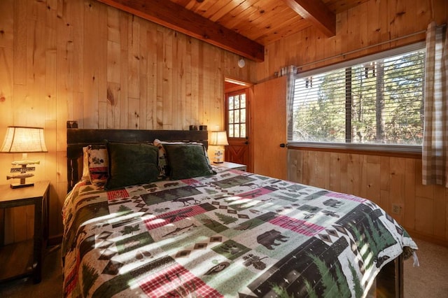 carpeted bedroom with beamed ceiling, wooden walls, and wooden ceiling