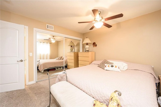 bedroom with light colored carpet, ceiling fan, and a closet