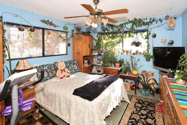 bedroom with a textured ceiling and ceiling fan