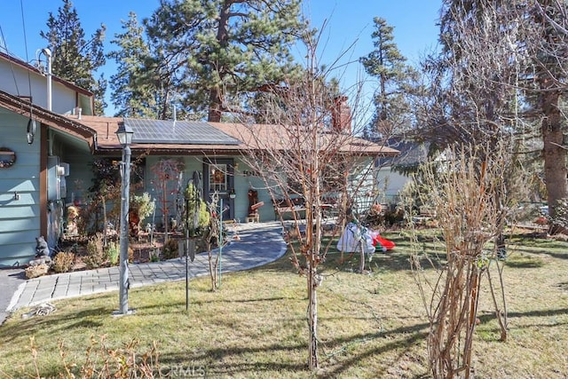 exterior space featuring a front lawn and solar panels