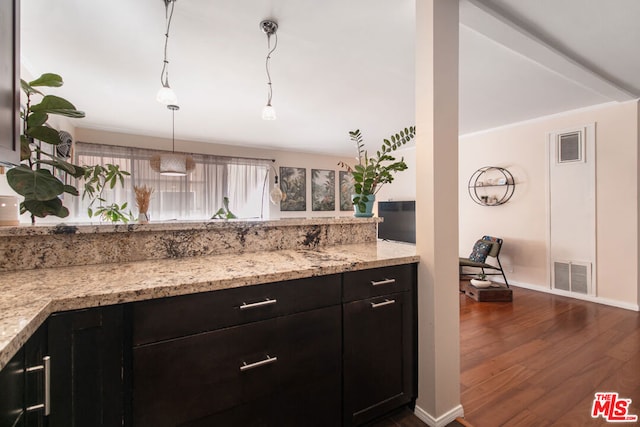 kitchen with hanging light fixtures, dark hardwood / wood-style flooring, and light stone counters