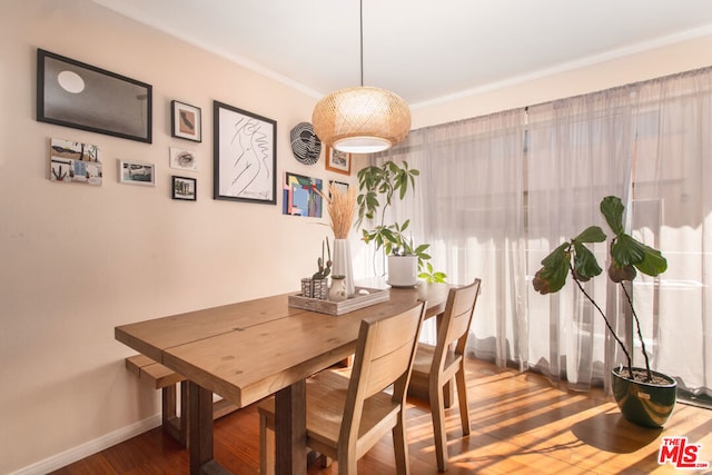 dining room with hardwood / wood-style floors and crown molding