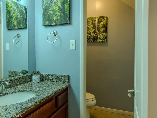 bathroom with tile patterned flooring, vanity, and toilet