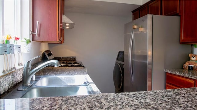 kitchen featuring washer / clothes dryer, sink, stainless steel fridge, range, and wall chimney range hood