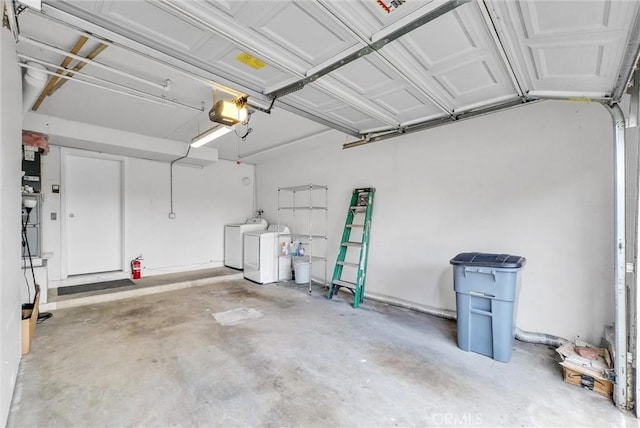 garage with a garage door opener and washer and dryer