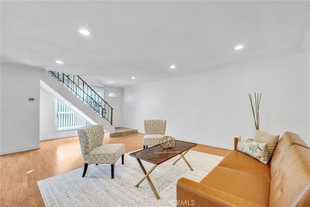 living room featuring ornamental molding and light hardwood / wood-style flooring