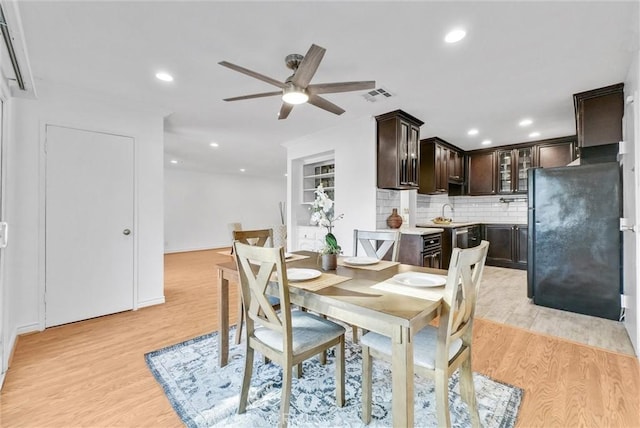 dining room with ceiling fan, sink, and light wood-type flooring