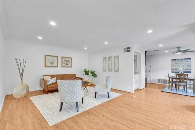 dining room featuring ceiling fan, ornamental molding, and light hardwood / wood-style floors