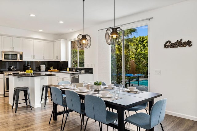 dining area featuring a healthy amount of sunlight, dark wood-type flooring, and sink