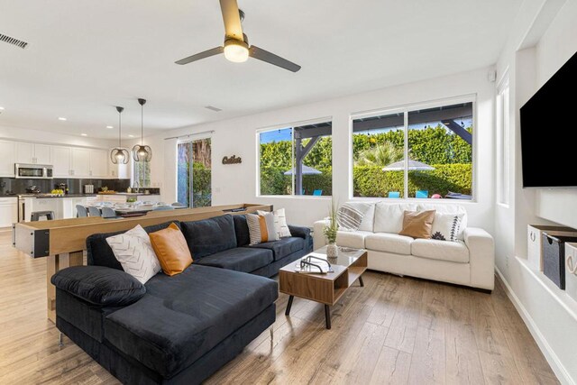 living room with ceiling fan and light hardwood / wood-style floors