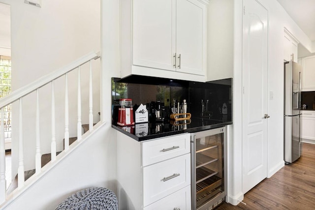 bar featuring white cabinets, stainless steel fridge, tasteful backsplash, and wine cooler