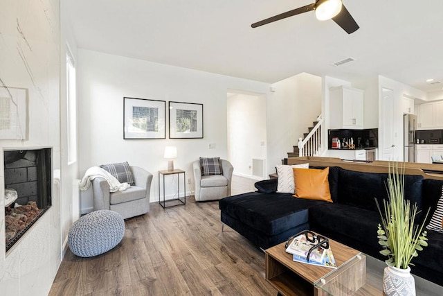 living room featuring wood-type flooring and ceiling fan