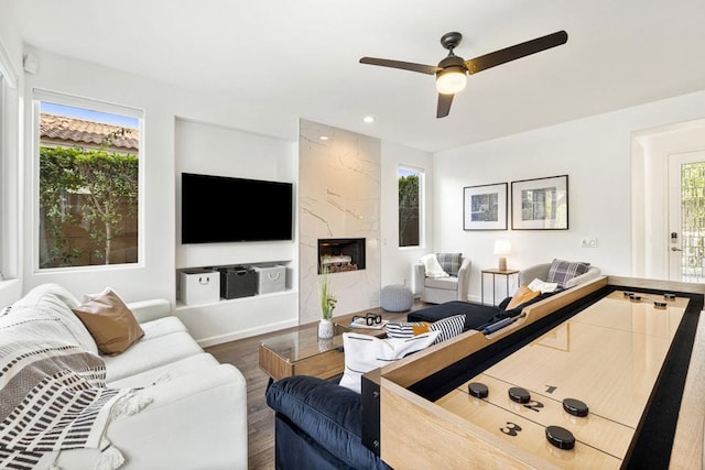 living room featuring dark hardwood / wood-style flooring, a high end fireplace, and ceiling fan