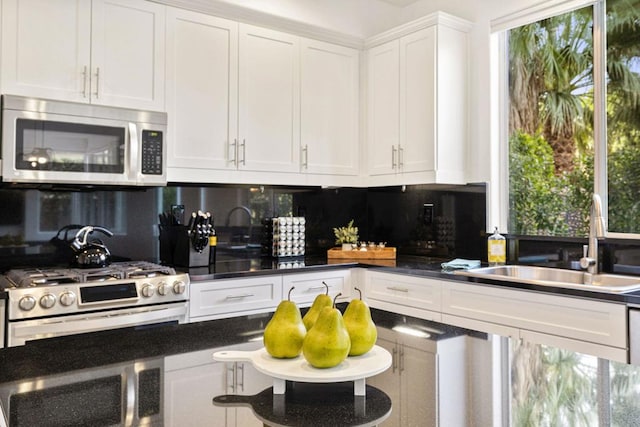 kitchen featuring stainless steel appliances, tasteful backsplash, sink, and white cabinets