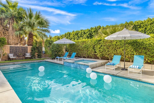 view of swimming pool with an in ground hot tub and a patio area