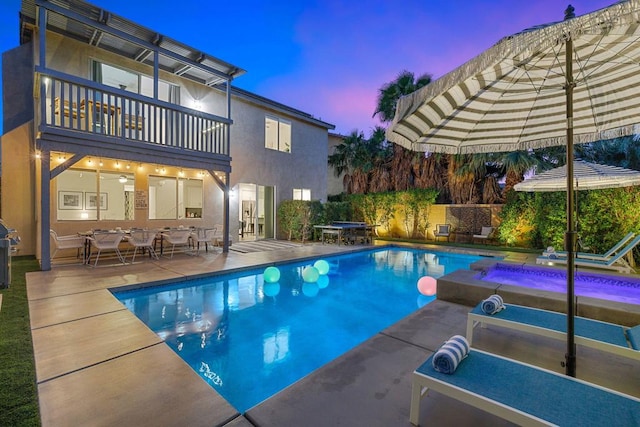 pool at dusk with a patio