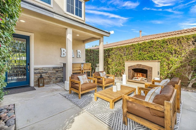 view of patio / terrace with an outdoor living space with a fireplace