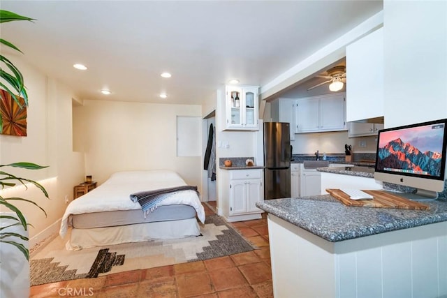 kitchen with white cabinetry, light tile patterned floors, stainless steel refrigerator, kitchen peninsula, and ceiling fan